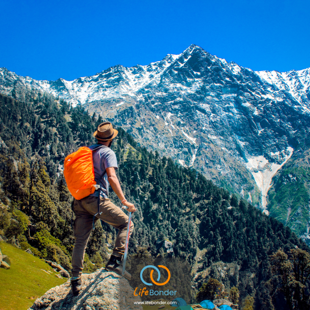 This picture depicts solo travelling. With mountains in the backgroun, a man with orange backpack looks towards the nature. The logo of LifeBonders appear at the bottom.
