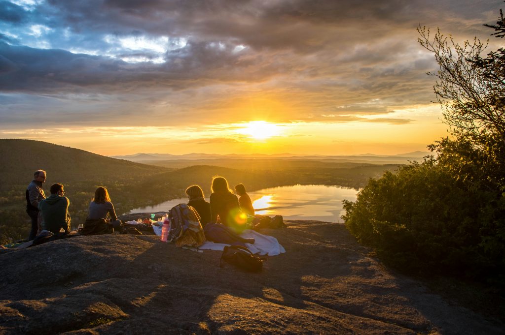 People looking at the sunset on a mountain in the nature.